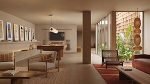 A modern living room with a sofa, armchairs, a coffee table, a dining area with a table and chairs, and a large window with a view of greenery. - Sabatic Formentera Autograph Collection (Formentera)
