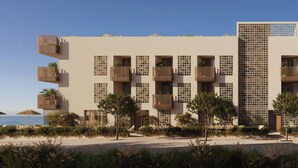 A modern building with multiple balconies, a pool area, and a view of the sea. - Sabatic Formentera Autograph Collection (Formentera)