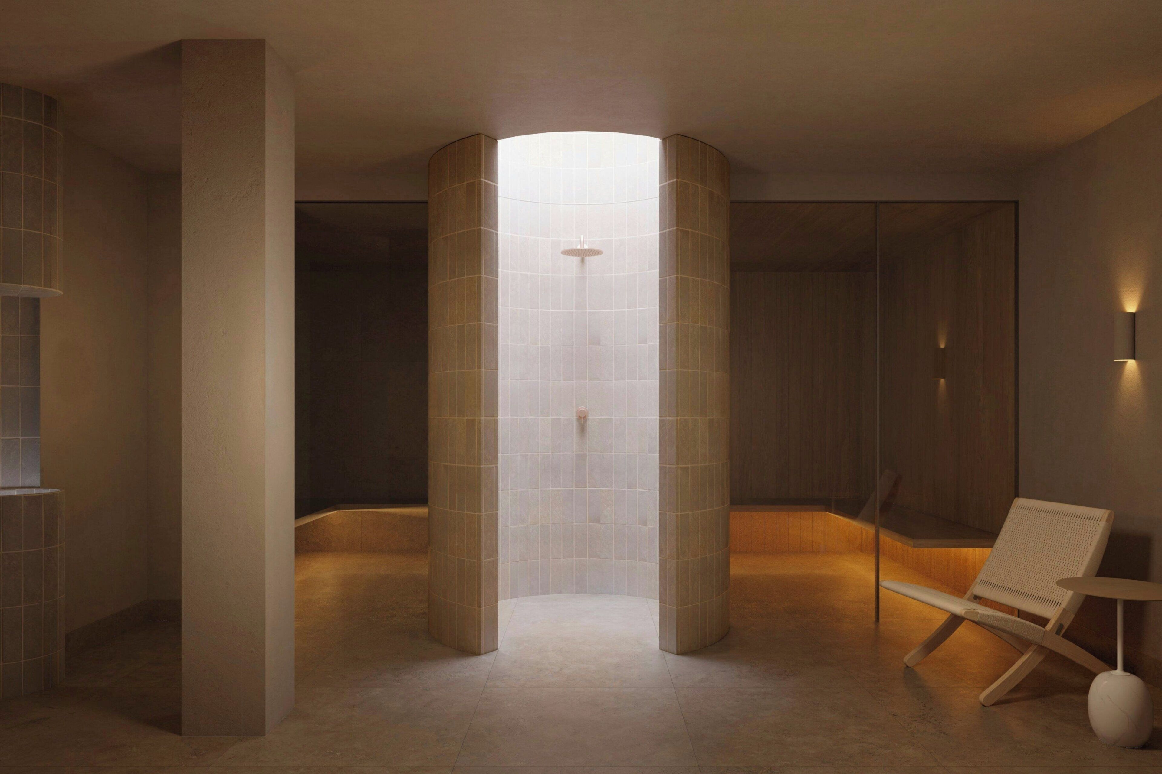A modern bathroom with a central column, a shower area, and a seating area.