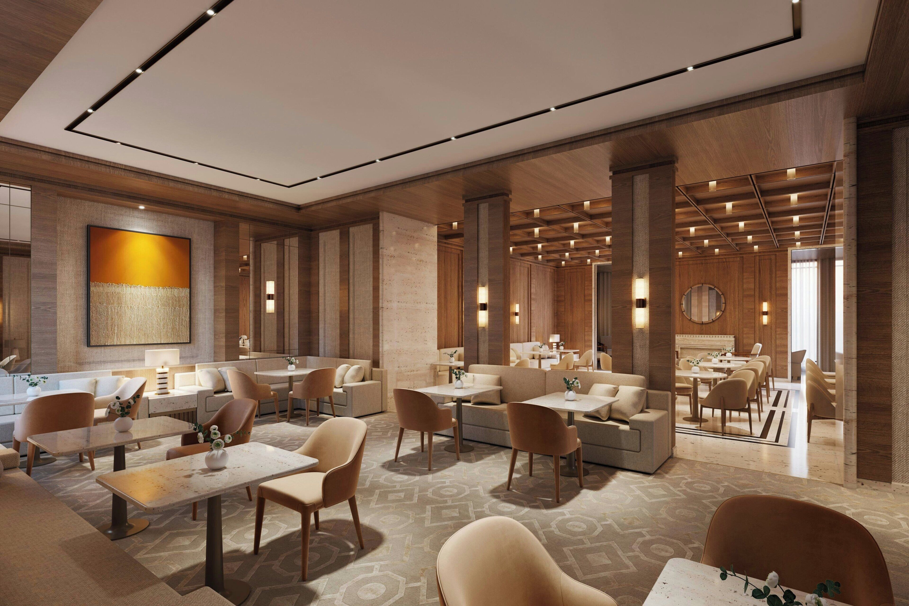 A modern hotel lobby with seating areas, a dining area, and a reception desk.