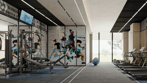 Un gimnasio con equipo de ejercicio, un mural de atletas y vistas a través de amplias ventanas.