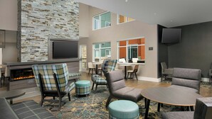 A modern lounge area with a fireplace, seating, and a flat-screen TV. - Residence Inn by Marriott Warner Robins (Warner Robins)