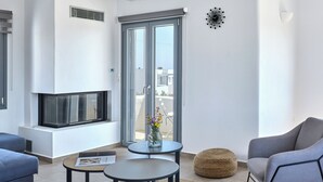 Een moderne woonkamer met een open haard, een groot raam en uitzicht op de stad.