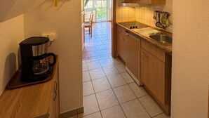 Cucina con una macchina del caffè, mobili in legno e una finestra.