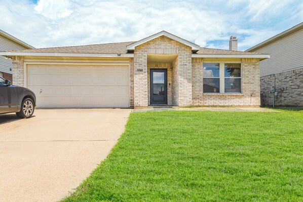 A single-story house with a garage, a front door, and a small porch.