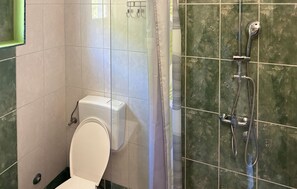 Ein Badezimmer mit Toilette, einer Dusche inklusive Duschbrause und einem Handtuchhalter.
