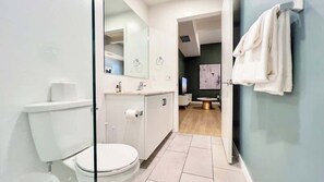 Ein modernes Badezimmer mit Toilette, Waschbecken und Spiegel.