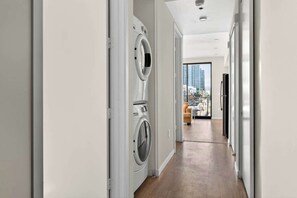A modern apartment with a laundry area, a view of the city, and a balcony. - Modern Downtown Retreat | Balcony + Rooftop Views (San Diego)