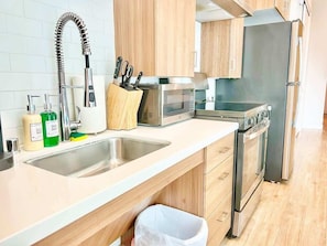 Eine moderne Küche mit Edelstahlgeräten, einer doppelten Spüle und Holzschränken.