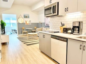 A modern kitchen with a dishwasher, microwave, and coffee maker. - Stylish San Diego Apt | Gaslamp at Your Door (San Diego)