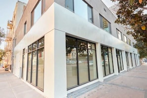A modern building with large windows, a flat facade, and a sidewalk. - Bars, Eats & Nightlife | Central San Diego King Apt (San Diego)