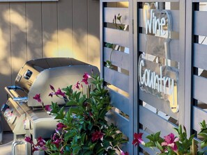 Ein Grill, ein Holzzaun und ein Schild mit der Aufschrift 'Wine Country'.