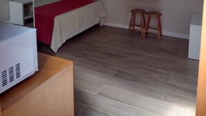 A bedroom with a bed, a desk, two stools, and a radiator. - Morada Bem Me Quer (Canela)