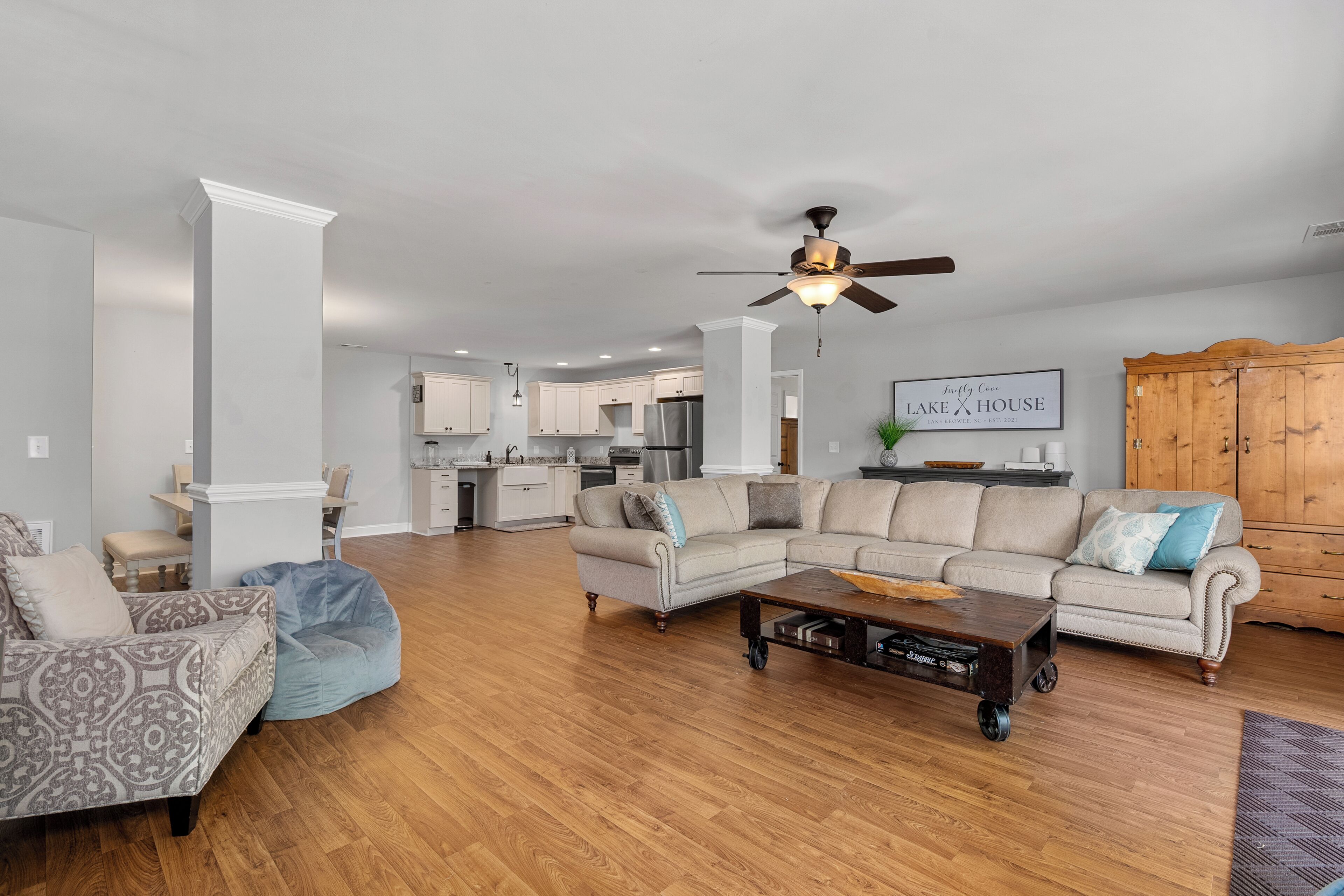 A spacious living room with a sectional sofa, a coffee table, and a ceiling fan.