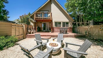 A house with a patio, outdoor seating, and a fire pit.