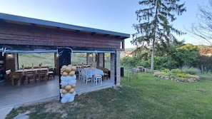 An outdoor patio with tables and chairs, a decorative balloon arch, and a view of a grassy area with trees. - Adorable and premium 2-bedroom house with AC in welcoming Vrdnik (Vrdnik)