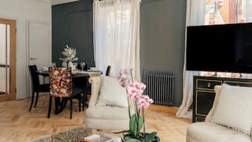 A living room with a dining area, a television, and a fireplace.