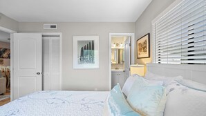 A bedroom with a bed, a wardrobe, a framed picture, and a window with blinds. - Relaxing Beach Retreat Villa, Walk to Beach and Resort (Hilton Head)
