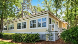 A single-story house with a front porch, a small staircase, and a well-maintained garden. - Beautiful & Spacious Golf View Villa Next to Pool (Hilton Head)