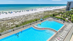 Ein Poolbereich mit Blick auf den Strand und den Ozean.