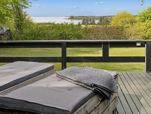 A deck with a view of a lake and greenery. - 4 Star Holiday Home in Roslev (Roslev)