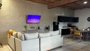 A living room with a sofa, a television, a kitchen area, and a dining table. - Casa Tonala 3 Rec. Wifi.A/c. FIFA 2026/GDL AirPort (Tonalá)