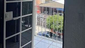 A view from a balcony with a metal railing, a tiled floor, and a clear sky with clouds. - Casa Tonala 3 Rec. Wifi.A/c. FIFA 2026/GDL AirPort (Tonalá)