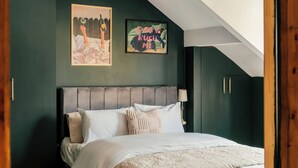 A bedroom with a bed, a headboard, a wall-mounted lamp, and two framed pictures. - Spacious Central Duplex, Walk to town + 2x Parking (Harrogate)