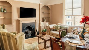 A living room with a fireplace, television, sofa, and dining table. - Spacious Central Duplex, Walk to town + 2x Parking (Harrogate)