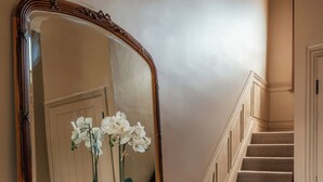 A wooden dresser with a large mirror, a staircase with carpeted steps, and a patterned rug on the floor. - Spacious Central Duplex, Walk to town + 2x Parking (Harrogate)