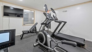 A gym with treadmills, an elliptical, and a stationary bike. - Eastern Inn Scenic Railway Suite (North Conway)