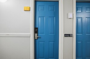 A blue door with a 'Thank You For Not Smoking' sign, a doorbell, and a light switch on the wall. - Eastern Inn Pine Grove Retreat (North Conway)