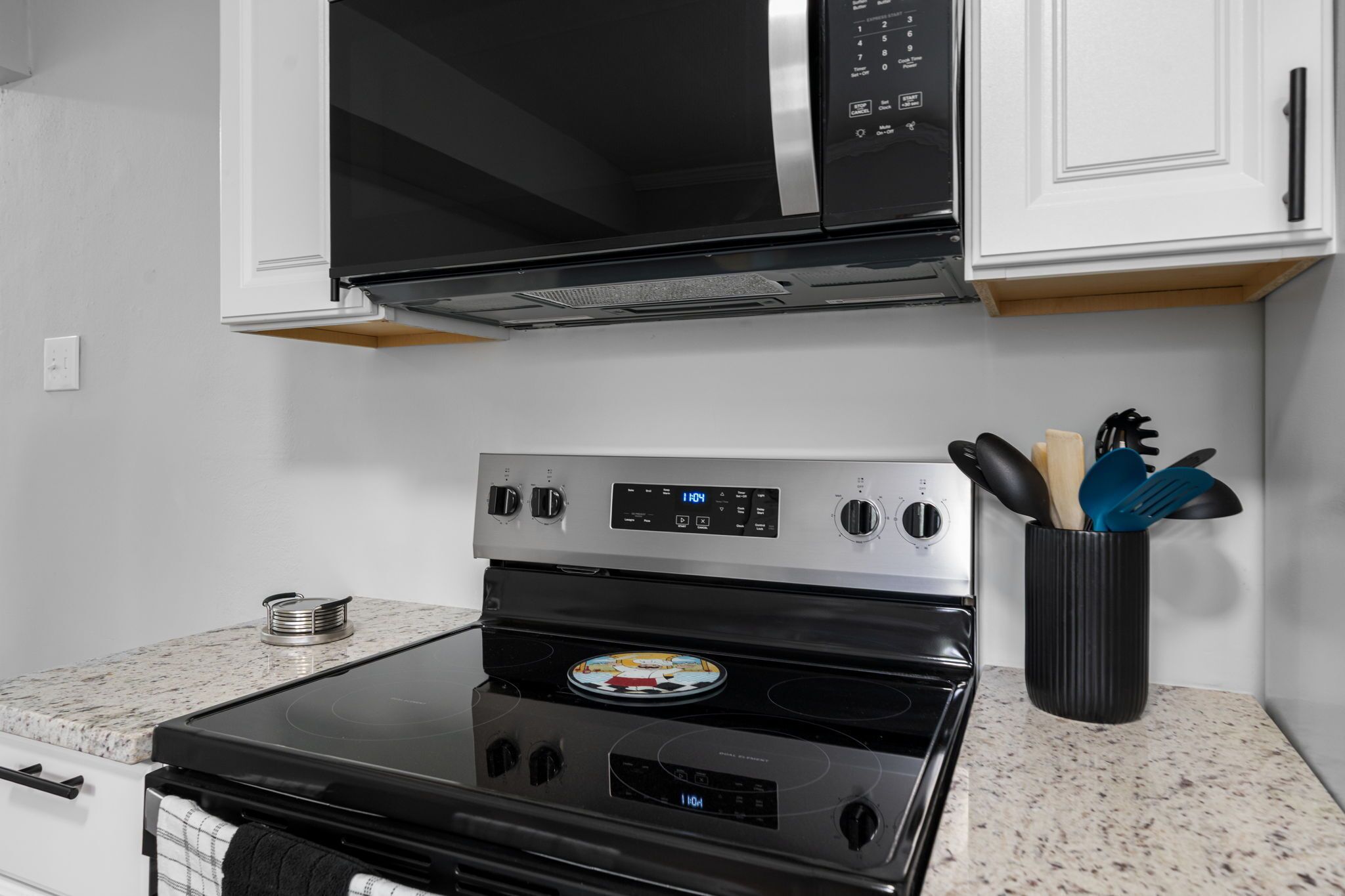 A kitchen with a microwave, oven, and a spice rack.