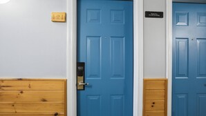 Una porta blu con un cartello 'Thank You For Not Smoking', un telaio di legno e un cartello con il numero '121' sulla parete.