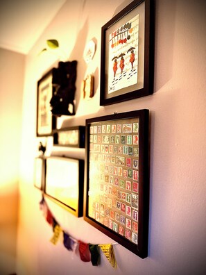 A wall with multiple framed items, including a collection of postage stamps and a framed artwork. - Having difficulties with the website - not accepting bookings at this time. (Charleston)