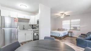 Un espacio habitable compacto con kitchenette, comedor, cama y zona de estar.