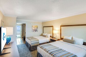 A hotel room with two beds, a desk with a lamp, and a view of the outside. - Oceanfront Unit with Private Balcony and Pool Access (Myrtle Beach)