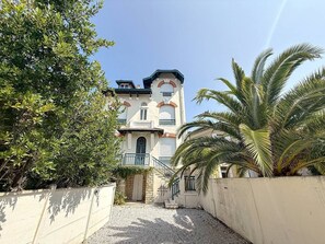 Ein Gebäude mit einer symmetrischen Fassade, einem zentralen Eingang und einer Treppe, die zum Haupteingang führt.