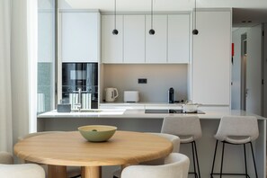 A modern kitchen with white cabinets, a central island, and pendant lighting.