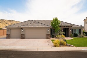 A single-story house with a garage, a stone accent wall, and a well-maintained lawn.