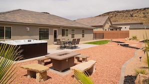 Zona residenziale con vasca idromassaggio, area salotto esterna e giardino curato.