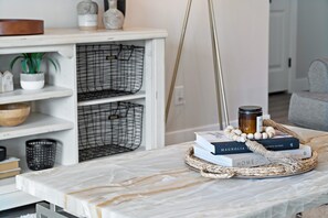 A marble table with books, a candle, and a woven basket. - Stunning 5BR Oasis • Hot Tub • Casita • Hurricane (Hurricane)