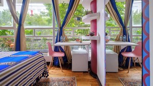 Una habitación con cama, escritorio y silla, y vistas a zonas verdes.