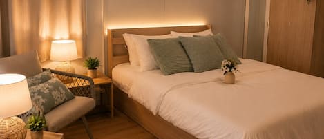 Une chambre bien rangée, avec un lit, des tables de chevet, une chaise et une armoire.