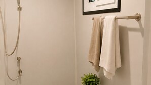 Une salle de bain comprenant des toilettes, un bidet, un lavabo, une douche et un tableau encadré au-dessus du miroir.