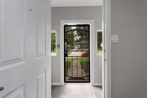 A hallway leading to a gated entrance with a view of a residential street. - 3BR One Level Ranch home + Easy Hwy Access (Kansas City)
