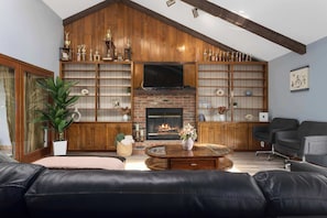 A living room with a fireplace, leather sofa, and a television. - Sleeps8!Remodeledw/ Smart TVs ,Near KC Stadium (Independence)