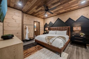 Un dormitorio con techo de madera, una cama con cabecera, una mesita de noche y una lámpara de pared.