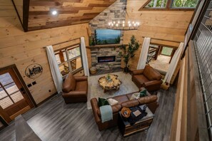 Un interior de madera con chimenea, sofás de cuero y una pared de acento de piedra.