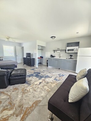 A modern living room with a sofa, ottoman, and a patterned rug. - Perfect location next to Ft Myers & Ft Myers Beach (Fort Myers)
